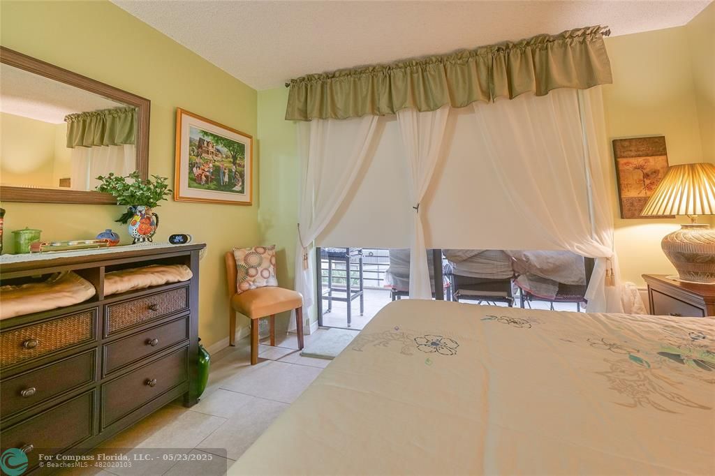 7300 Radice Court, Unit 302 Lauderhill, FL 33319 - Photo 36 of 81 a bedroom with a bed and a dresser in it