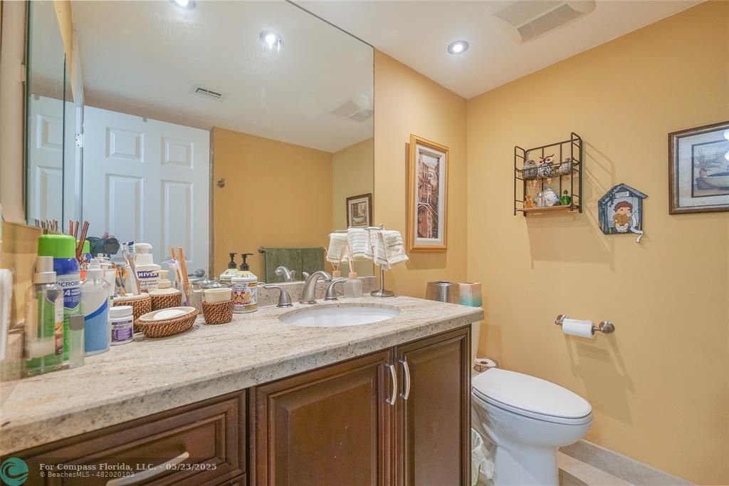 7300 Radice Court, Unit 302 Lauderhill, FL 33319 - Photo 37 of 81 a bathroom with a granite countertop sink mirror and toilet