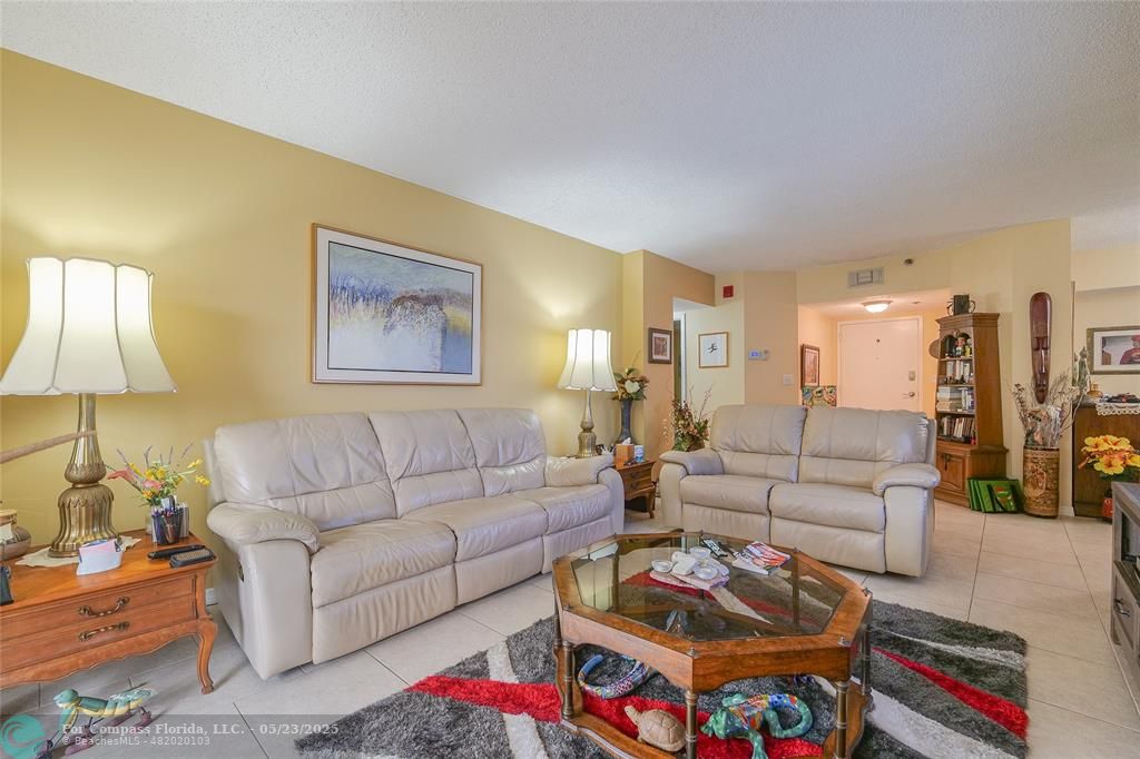 7300 Radice Court, Unit 302 Lauderhill, FL 33319 - Photo 5 of 81 a living room with furniture and a lamp