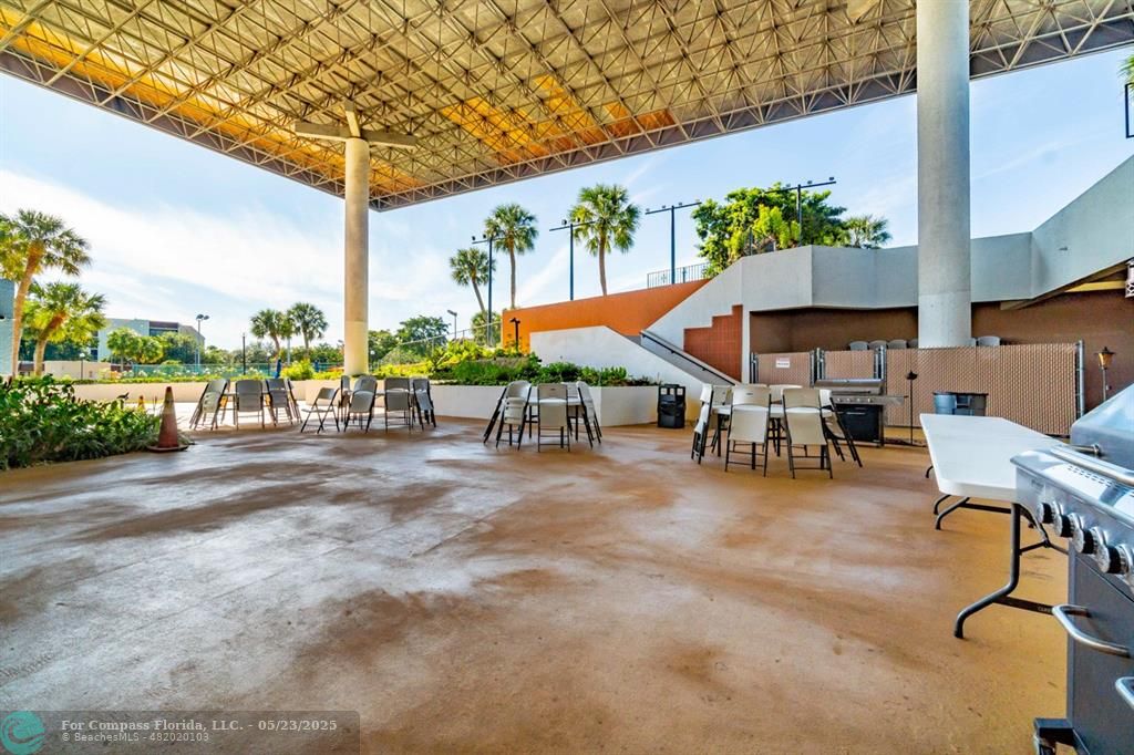 7300 Radice Court, Unit 302 Lauderhill, FL 33319 - Photo 55 of 81 a view of a patio with a table and chairs under an umbrella