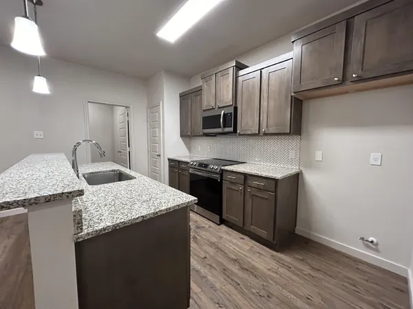 a kitchen with stainless steel appliances granite countertop a sink stove and microwave