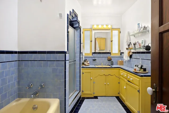 a bathroom with a tub sink and mirror