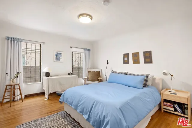 a bedroom with a bed and wooden floor
