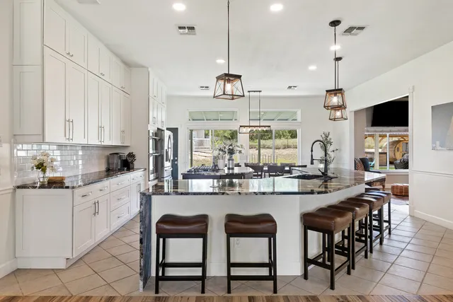 a kitchen with kitchen island granite countertop a table and chairs in it