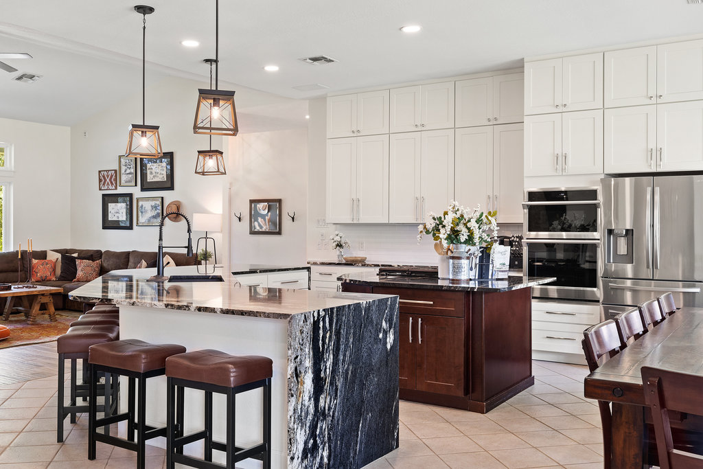 4607 R O Drive Spicewood, TX 78669 - Photo 15 of 40 a kitchen with stainless steel appliances kitchen island granite countertop a table chairs sink and cabinets