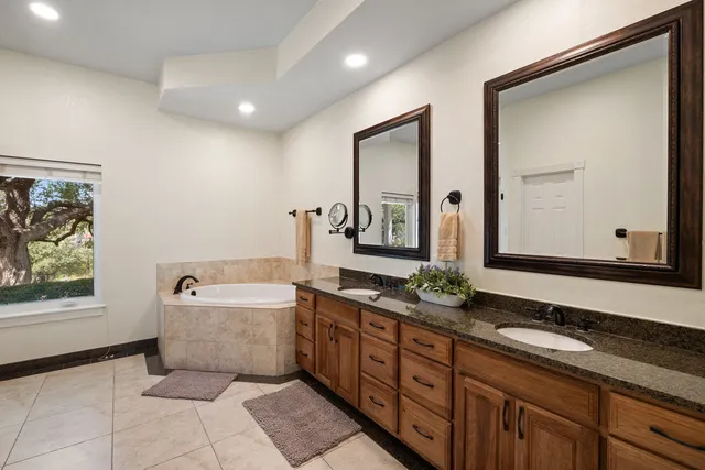 a spacious bathroom with a granite countertop sink and a mirror