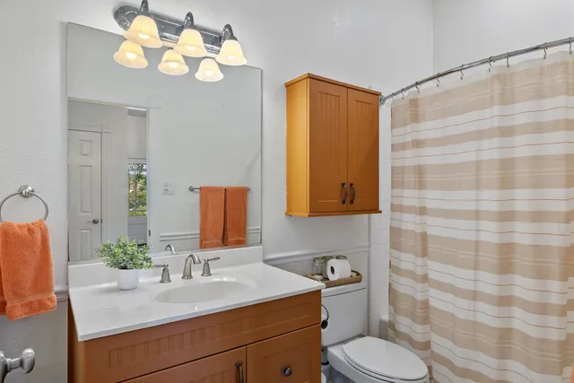 a bathroom with a sink vanity granite and toilet