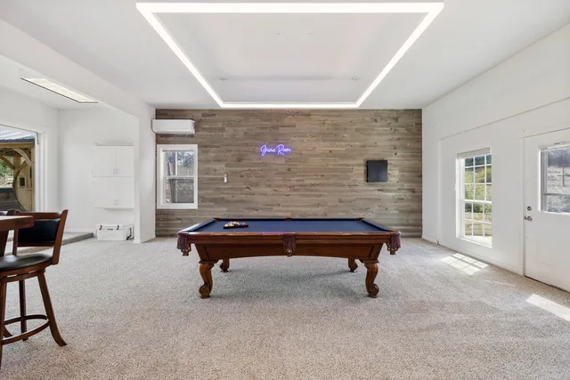 a room with pool table and windows