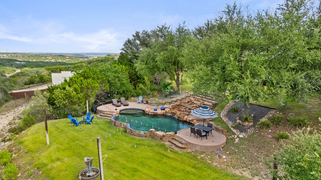 4607 R O Drive Spicewood, TX 78669 - Photo 8 of 40 a view of a backyard with table and chairs and potted plants