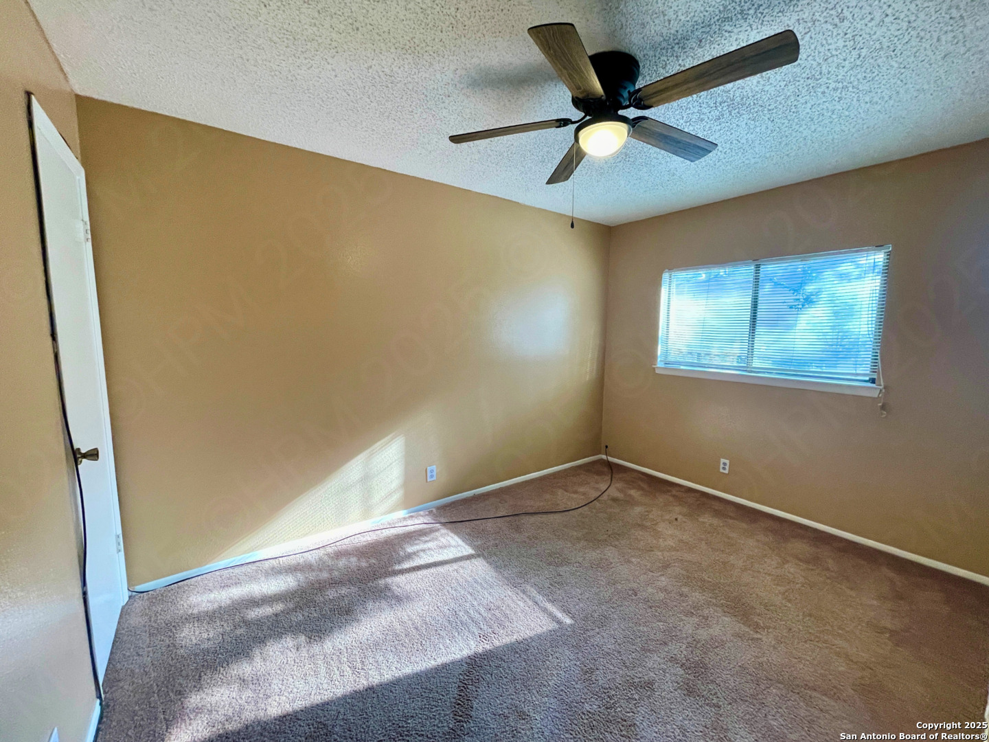 7318 Hunters Raven San Antonio, TX 78249 - Photo 12 of 18 an empty room with windows and ceiling fan