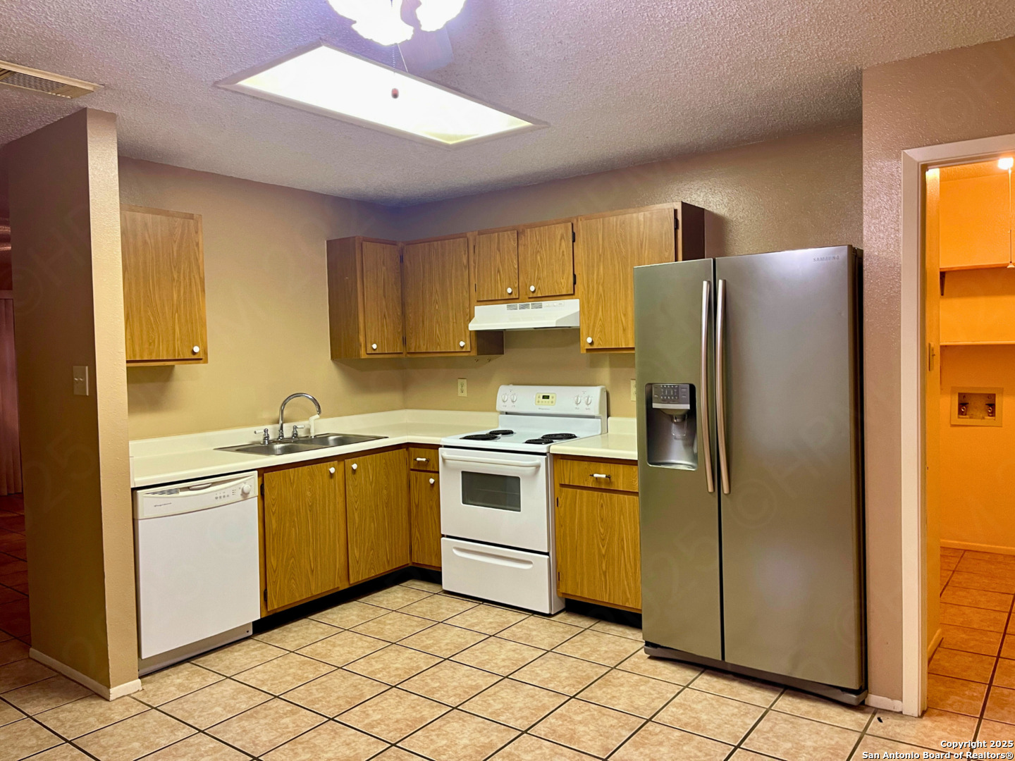 7318 Hunters Raven San Antonio, TX 78249 - Photo 9 of 18 a kitchen with stainless steel appliances granite countertop a refrigerator a sink a stove top oven and a dishwasher