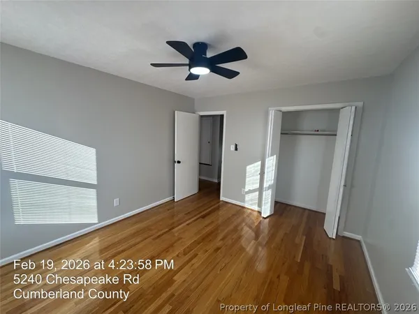 a view of empty room with wooden floor