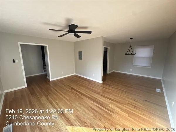 a view of empty room with wooden floor