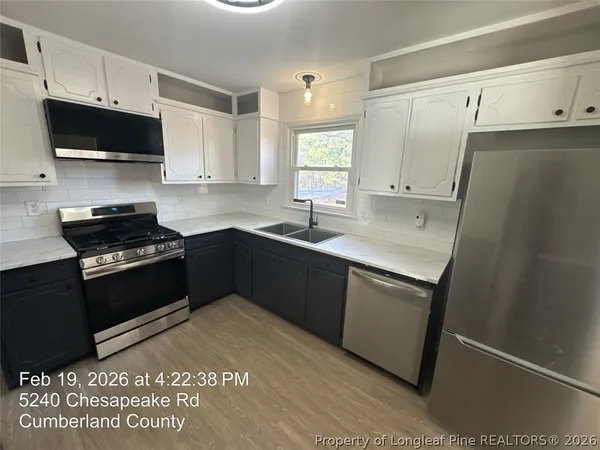 a kitchen with a sink appliances and cabinets