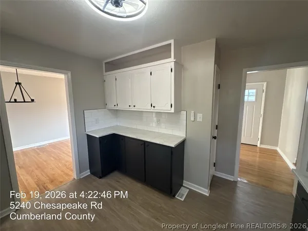 a kitchen with a wooden floor and cabinets