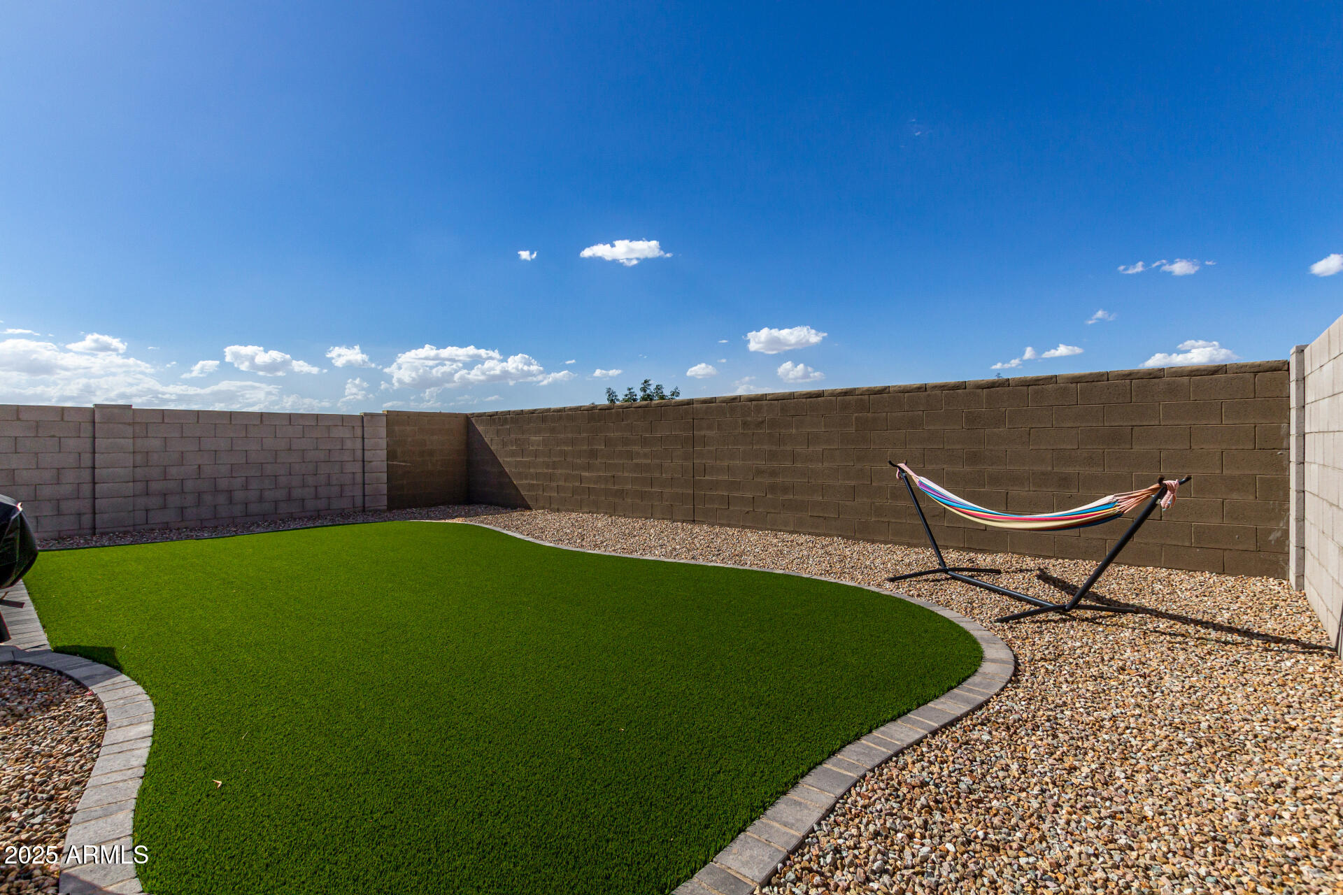 3226 West Stanton Avenue Apache Junction, AZ 85120 - Photo 33 of 34 a bench sitting in the grass near a wooden fence