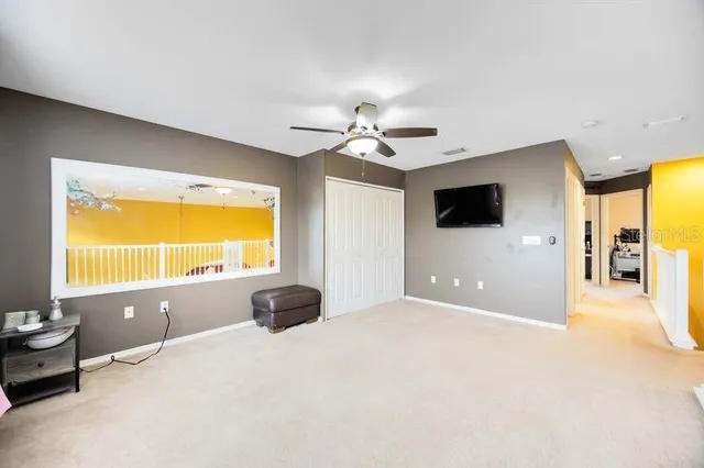 a view of an empty room with a window and a kitchen