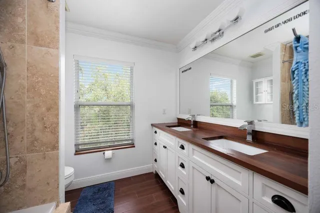 a bathroom with a granite countertop sink and a window