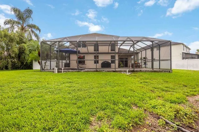 a view of a house with a big yard and large trees