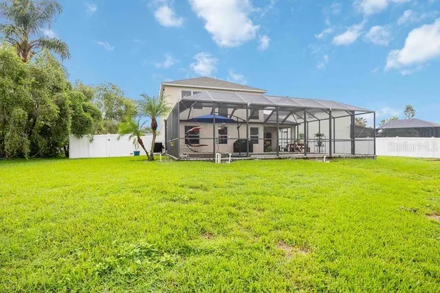 a view of a house with a big yard and large trees