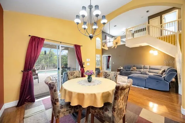 a view of a dining room with furniture a chandelier and wooden floor