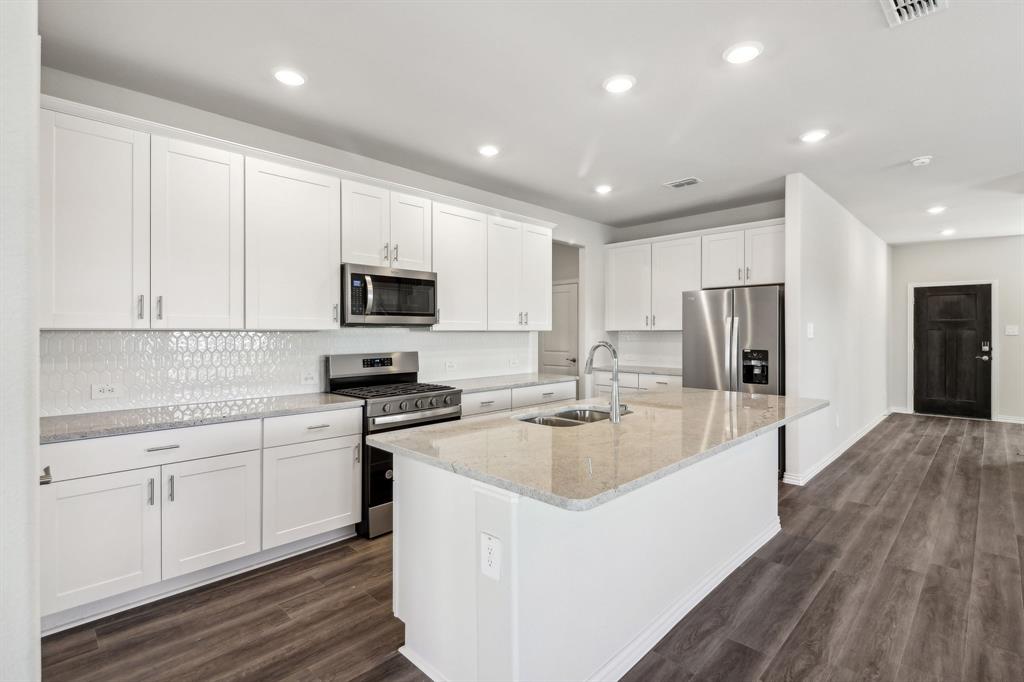 901 Edgehurst Drive McKinney, TX 75071 - Photo 1 of 1 a large kitchen with stainless steel appliances granite countertop a stove a sink a refrigerator and white cabinets with wooden floor