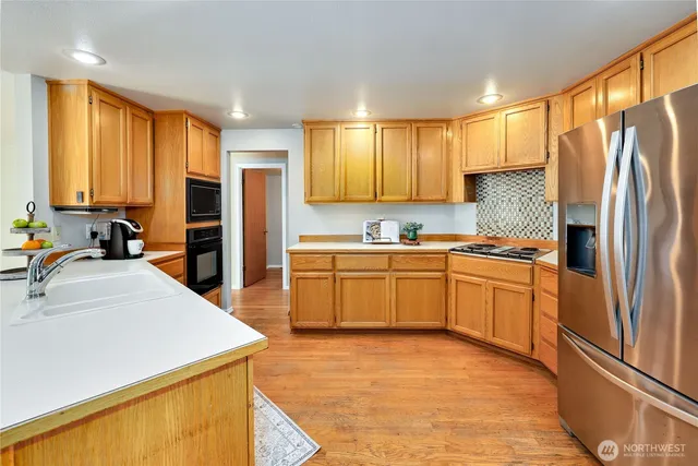 a kitchen with stainless steel appliances a refrigerator sink and cabinets