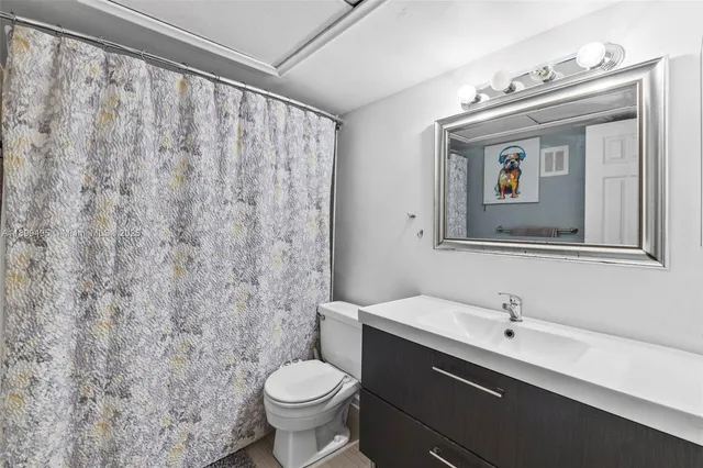 a bathroom with a bathtub shower sink mirror and toilet