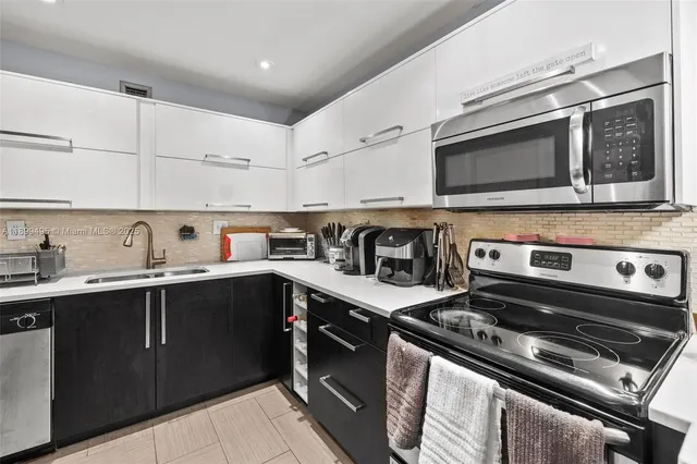 a kitchen with stainless steel appliances a stove sink and cabinets