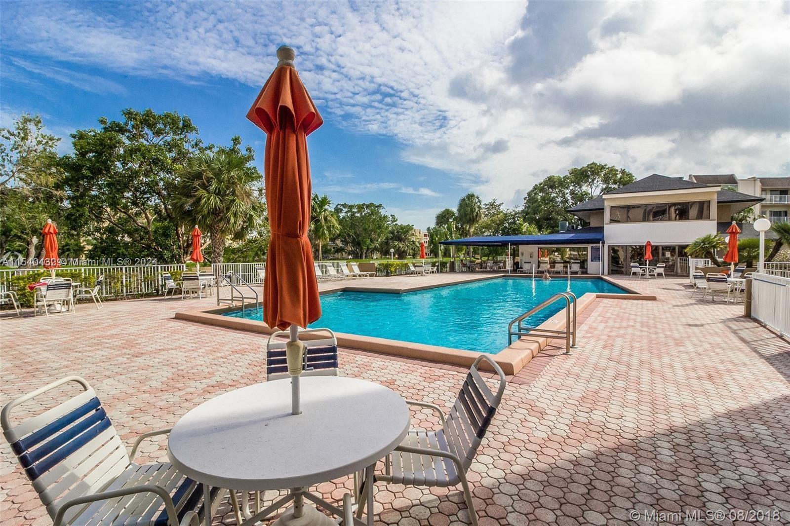 7785 Southwest 86th Street, Unit E116 Miami, FL 33143 - Photo 14 of 27 a swimming pool with outdoor seating and yard