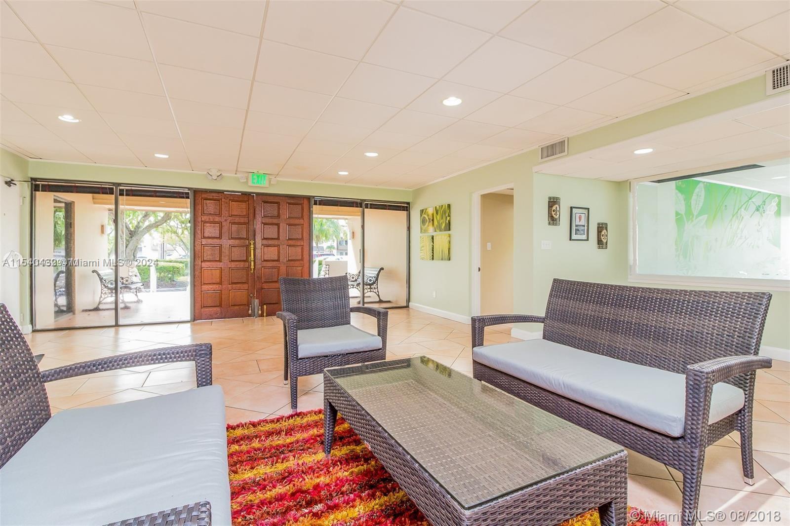 7785 Southwest 86th Street, Unit E116 Miami, FL 33143 - Photo 16 of 27 a living room with furniture and a large window