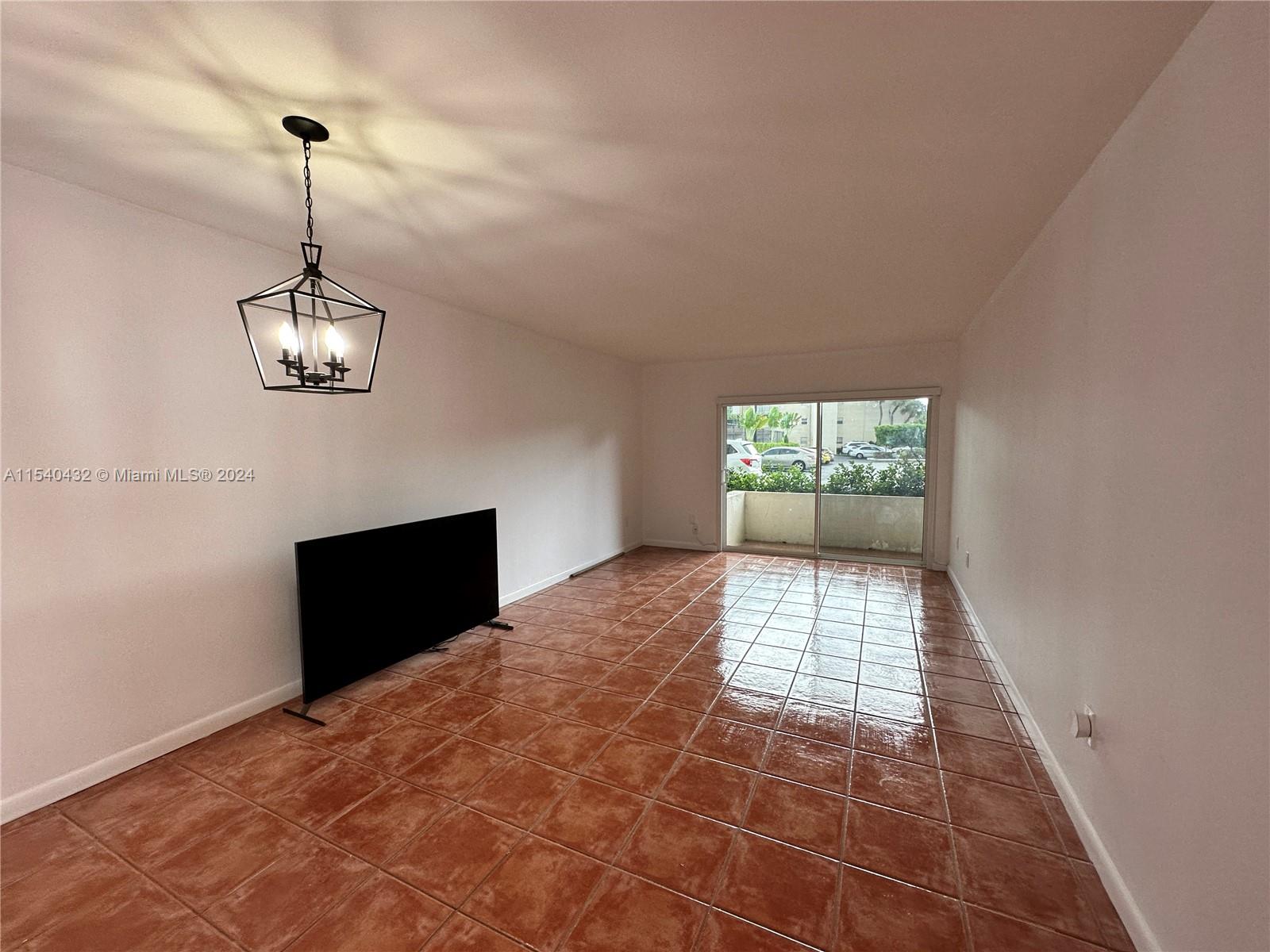 7785 Southwest 86th Street, Unit E116 Miami, FL 33143 - Photo 9 of 27 a view of a room with window and chandelier