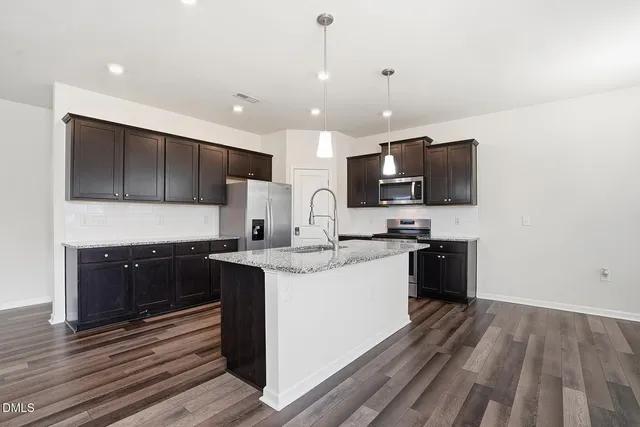 a kitchen with stainless steel appliances granite countertop a sink stove and microwave