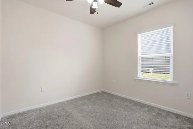 an empty room with a window and a ceiling fan