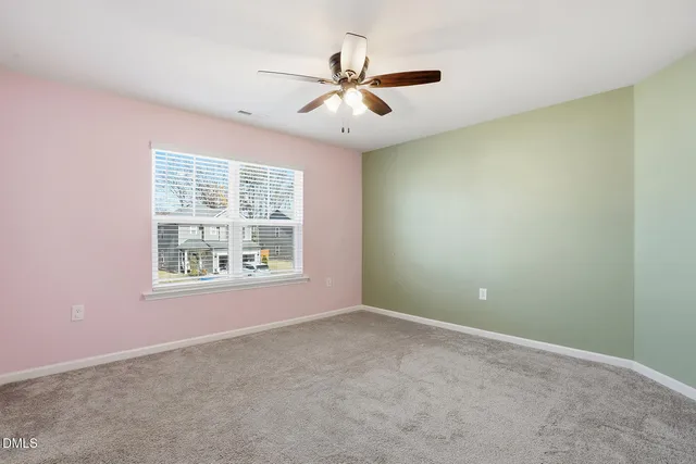 an empty room with window and ceiling fan