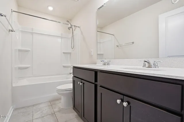 a bathroom with a double vanity sink toilet mirror and shower