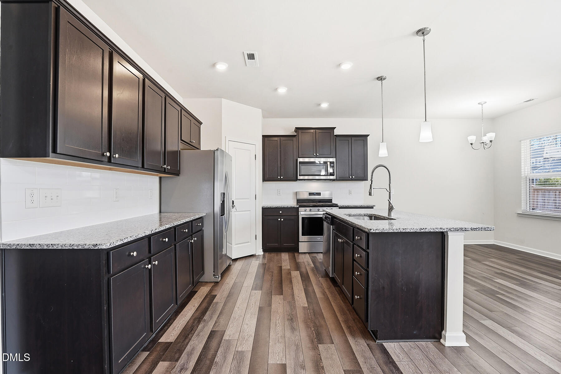 2116 Water Marsh Trail Fuquay-Varina, NC 27526 - Photo 8 of 28 a kitchen with stainless steel appliances granite countertop wooden cabinets a stove top oven a sink and dishwasher