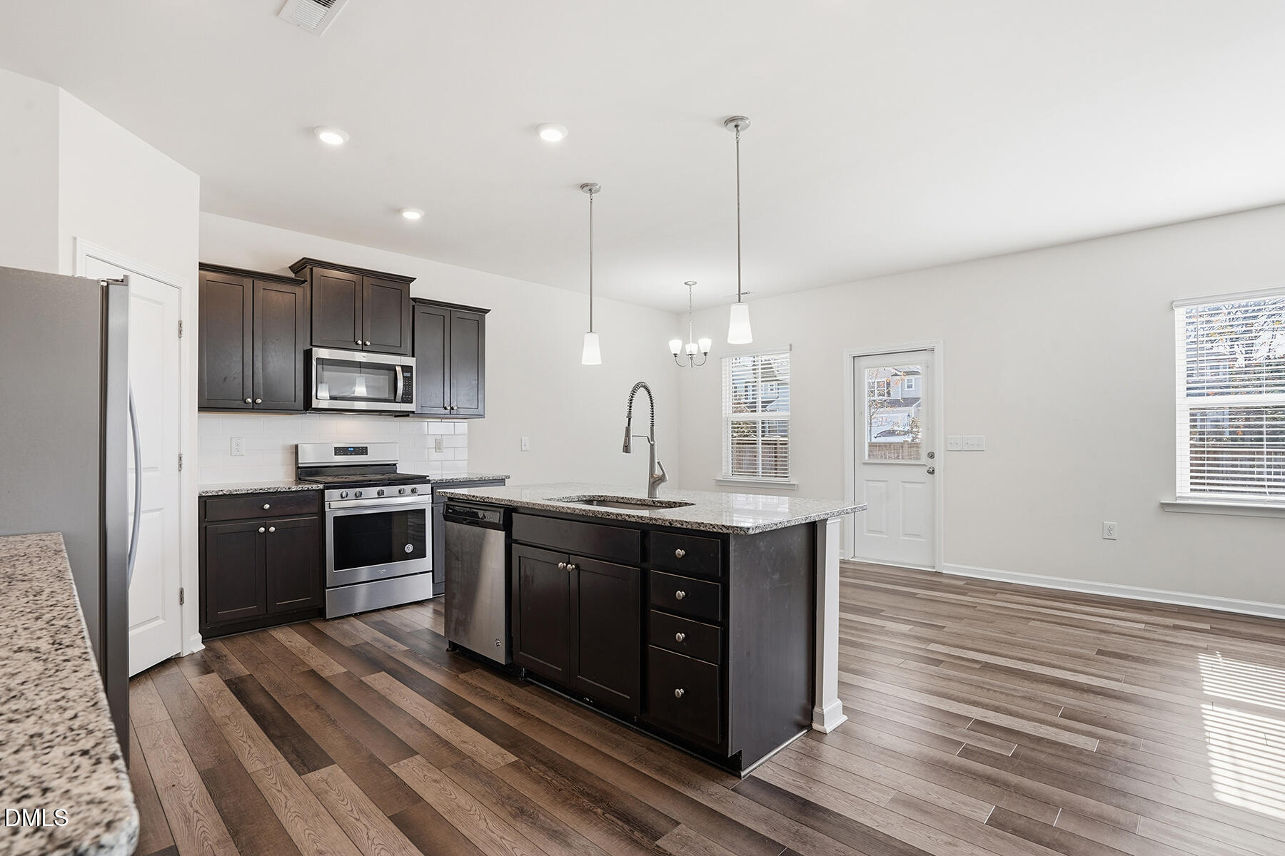 2116 Water Marsh Trail Fuquay-Varina, NC 27526 - Photo 9 of 28 a open kitchen with stainless steel appliances granite countertop a stove a sink dishwasher a refrigerator and a oven with wooden floor