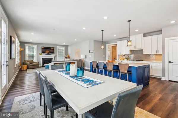 a kitchen with stainless steel appliances kitchen island granite countertop a sink a stove and a wooden floors