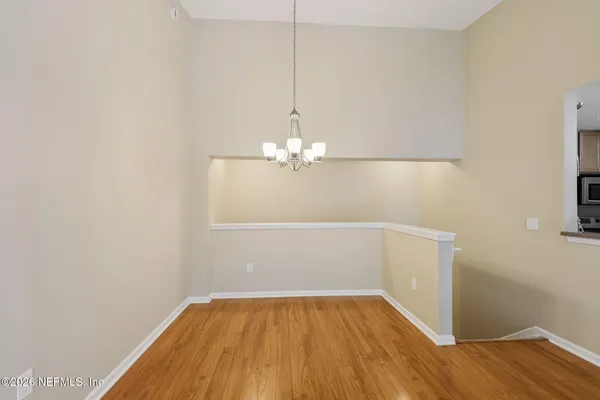 a view of a room with wooden floor and a ceiling fan