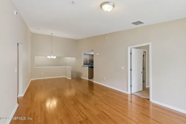 a view of empty room with wooden floor