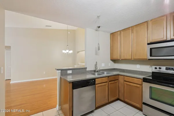 a kitchen with stainless steel appliances granite countertop a sink and a stove