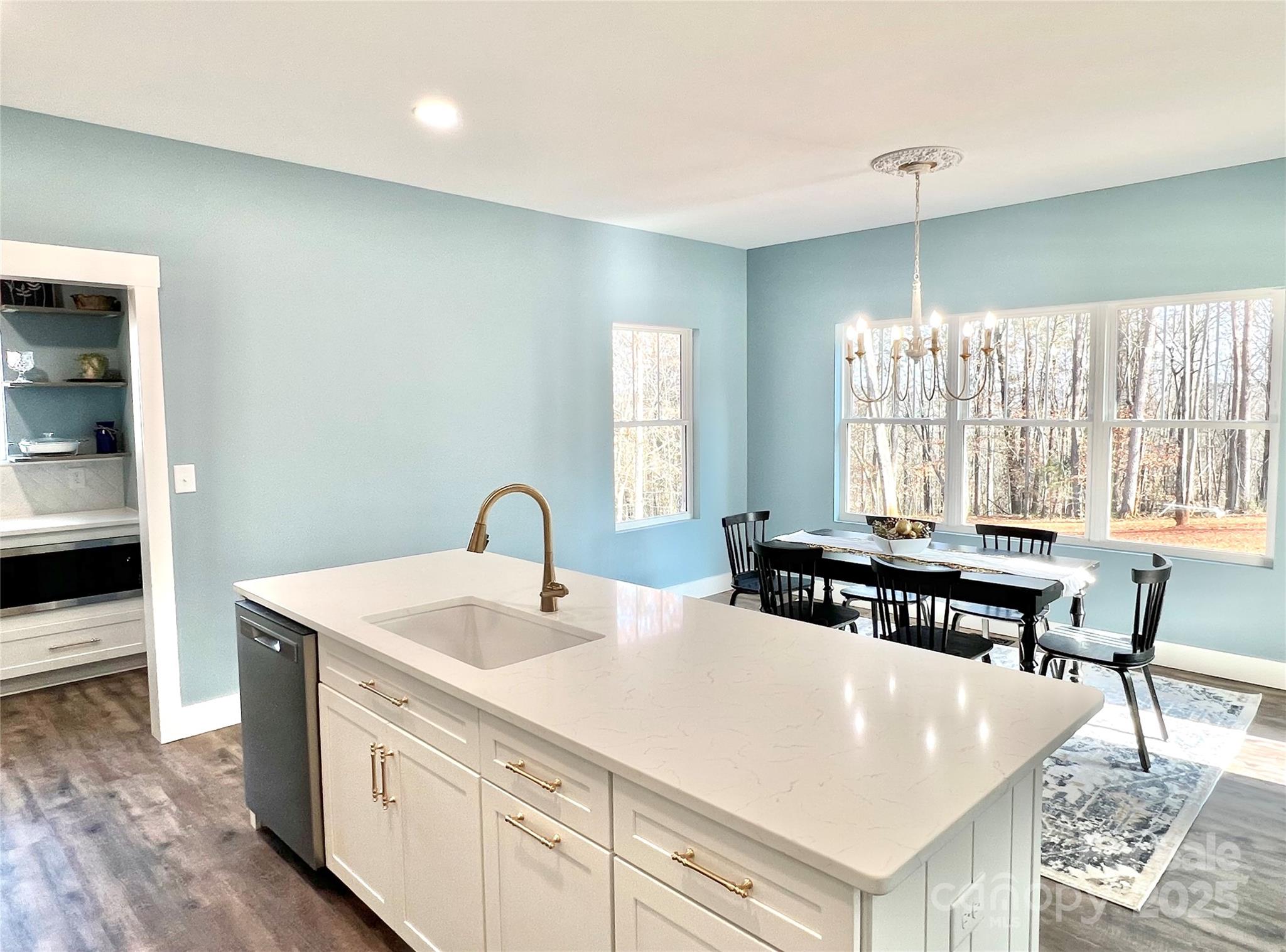122 Arrowood Lane Harmony, NC 28634 - Photo 8 of 47 a kitchen with a stove a sink and white cabinets with wooden floor