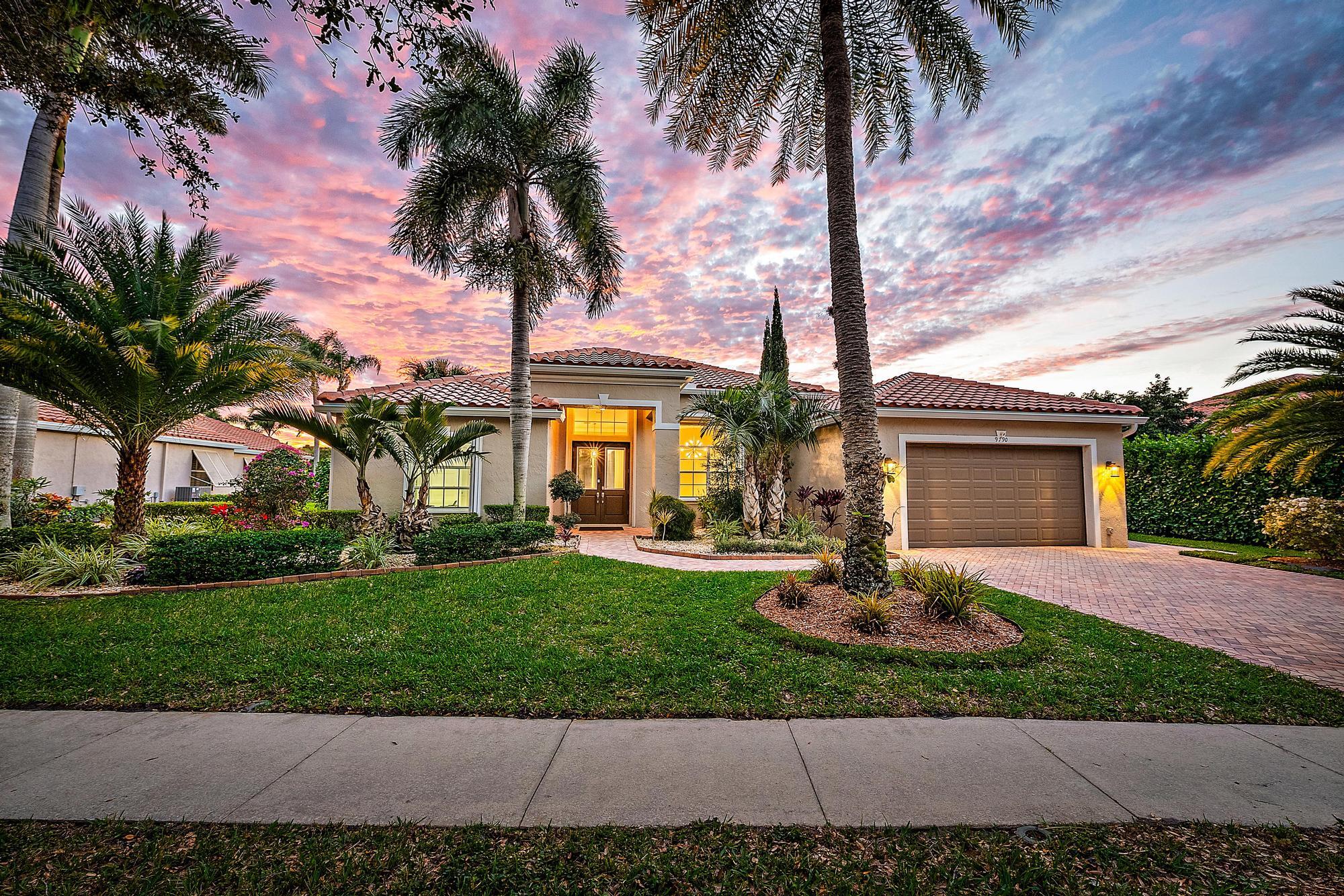 a view of a house with a yard and palm trees