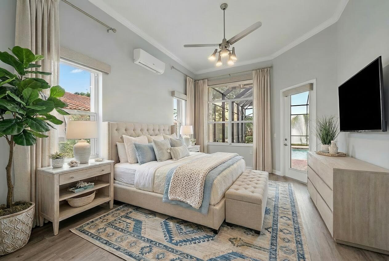 9790 Southeast Crape Myrtle Court Hobe Sound, FL 33455 - Photo 17 of 74 a spacious bedroom with a large bed and a flat screen tv