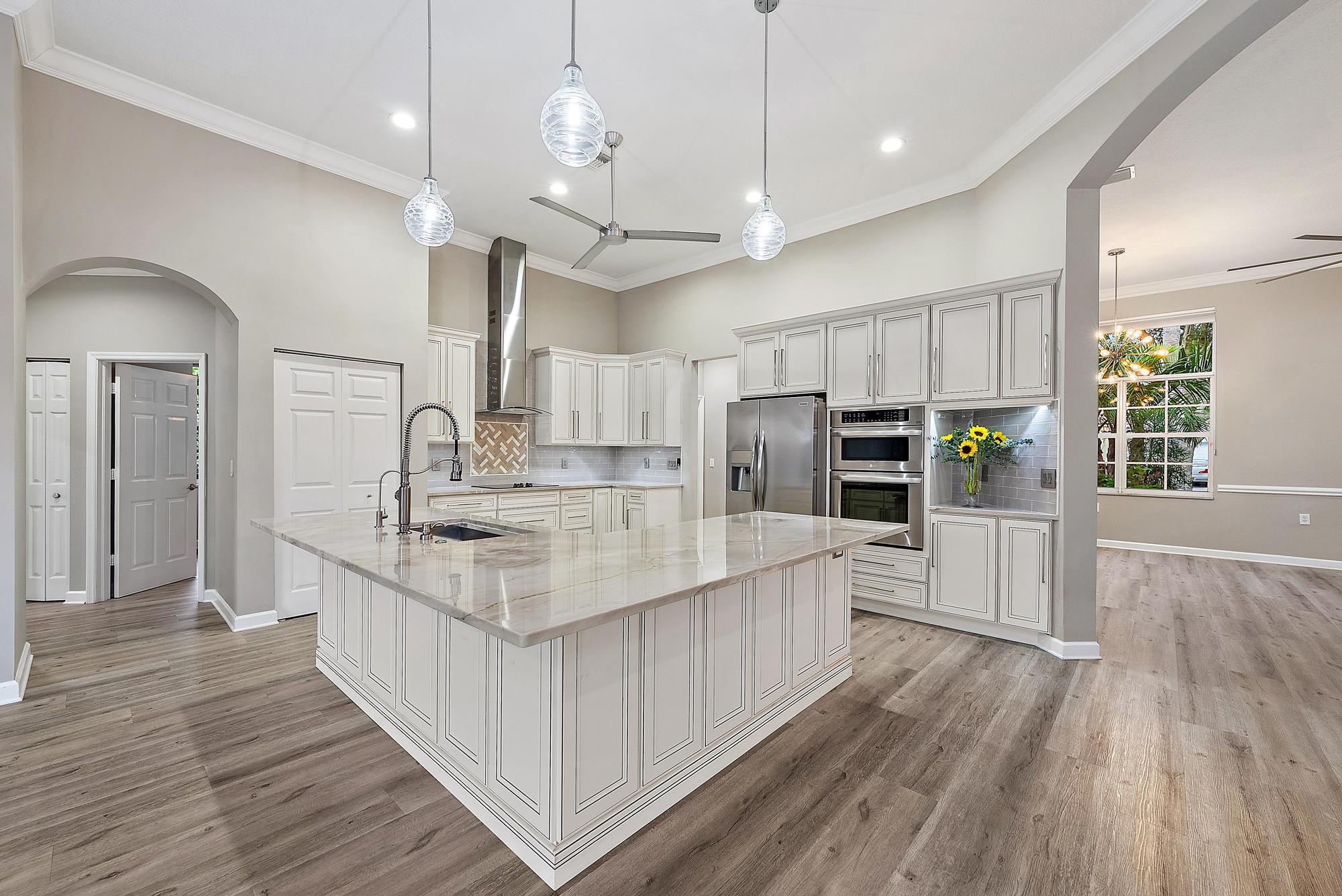 9790 Southeast Crape Myrtle Court Hobe Sound, FL 33455 - Photo 25 of 74 an open kitchen with wooden floor and stainless steel appliances