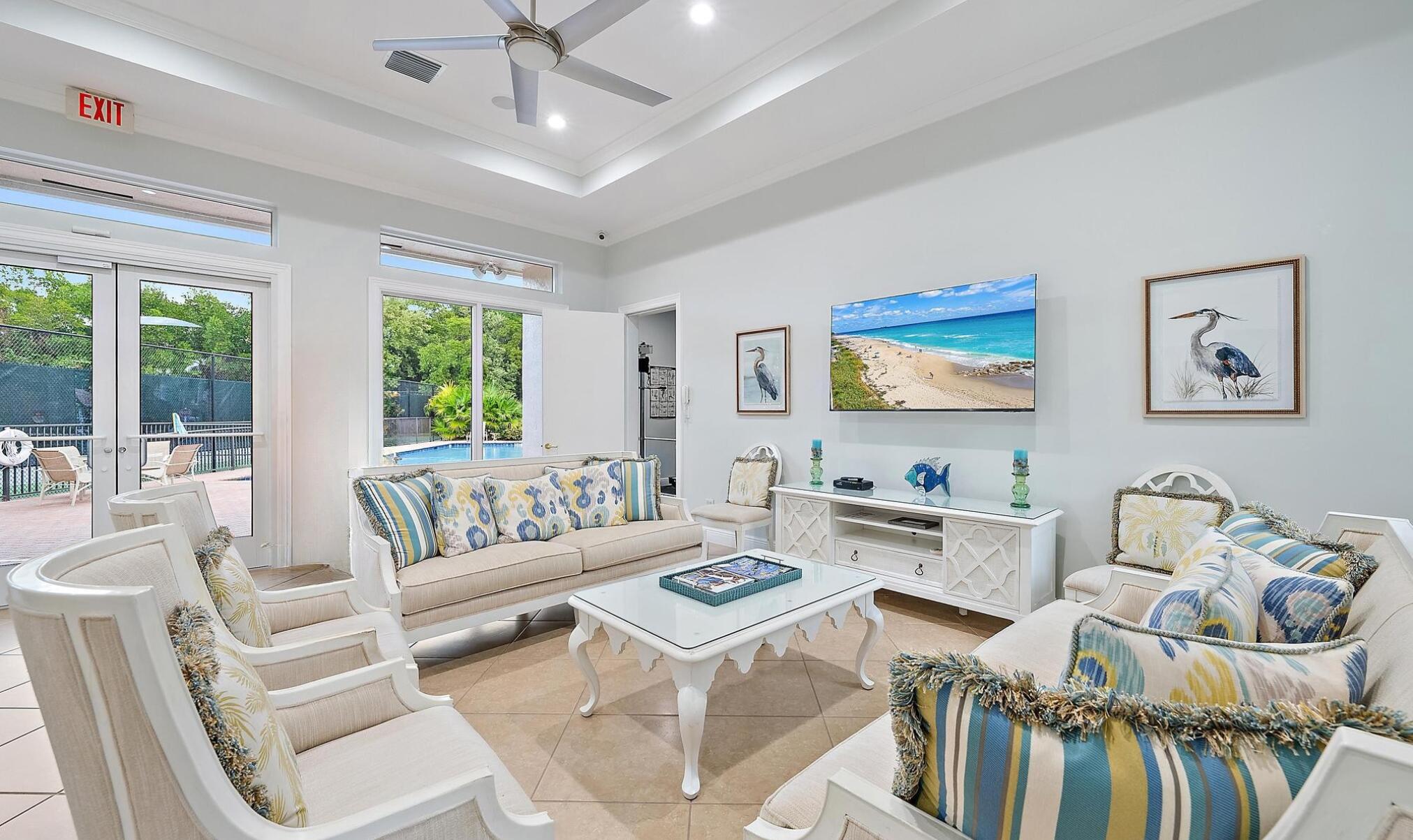 9790 Southeast Crape Myrtle Court Hobe Sound, FL 33455 - Photo 37 of 74 a living room with furniture a large window and a chandelier