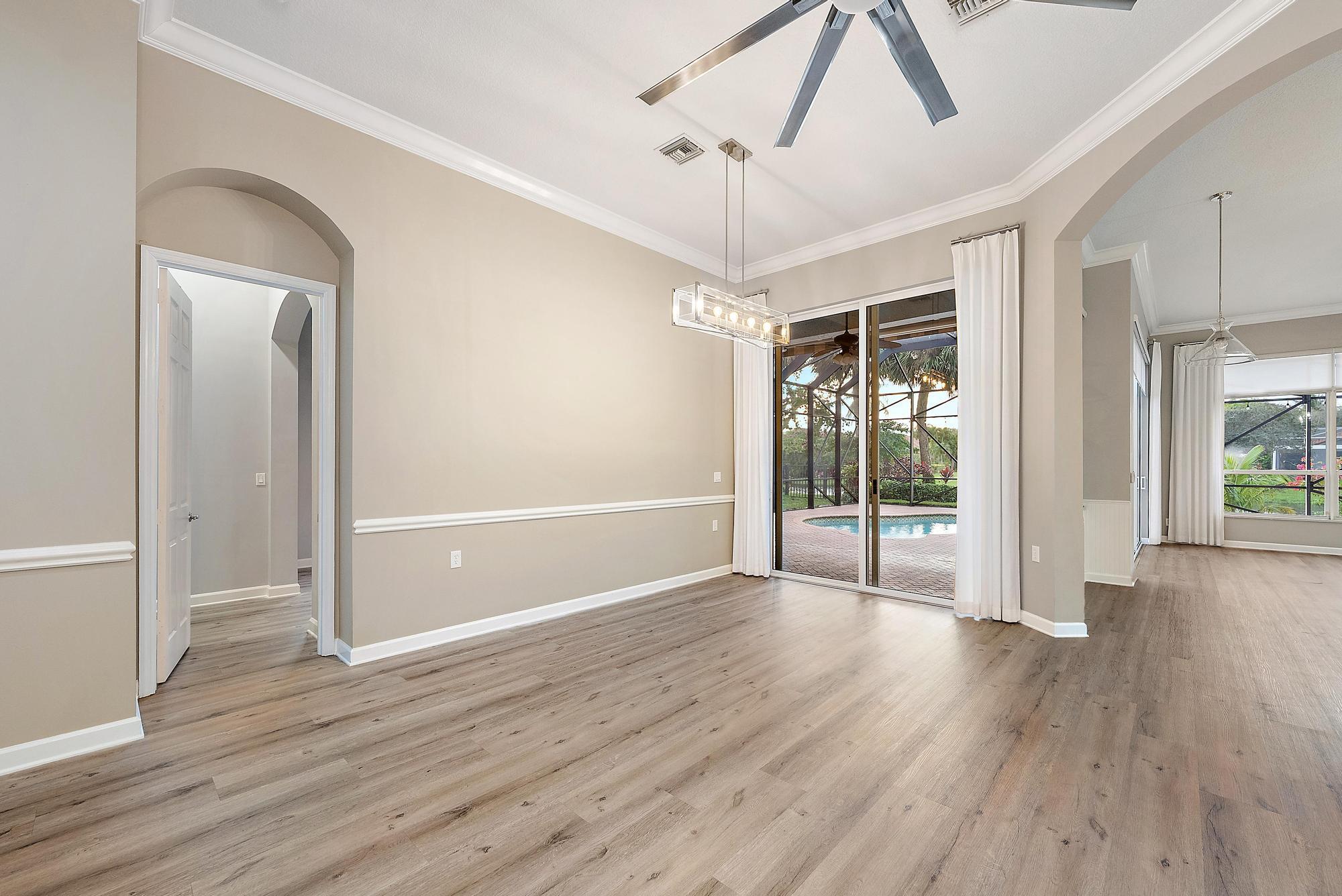 9790 Southeast Crape Myrtle Court Hobe Sound, FL 33455 - Photo 55 of 74 a view of an empty room with wooden floor fridge and a ceiling fan