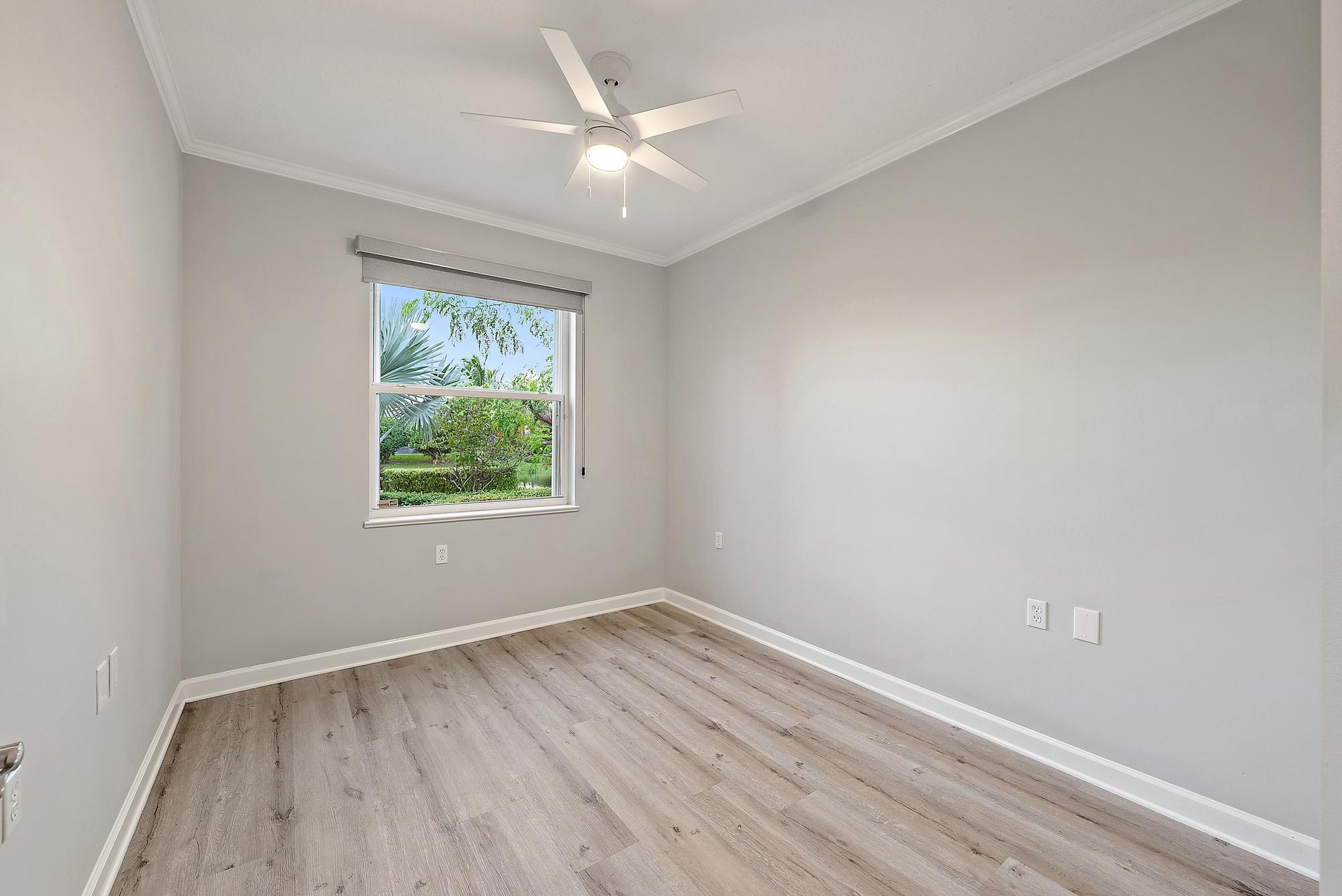 9790 Southeast Crape Myrtle Court Hobe Sound, FL 33455 - Photo 67 of 74 an empty room with wooden floor and windows