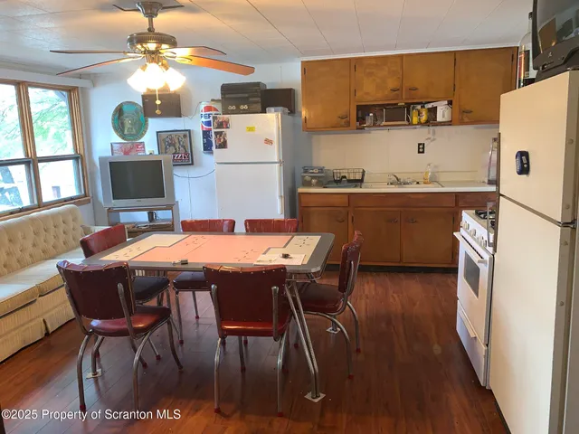 a kitchen with a table chairs refrigerator and microwave